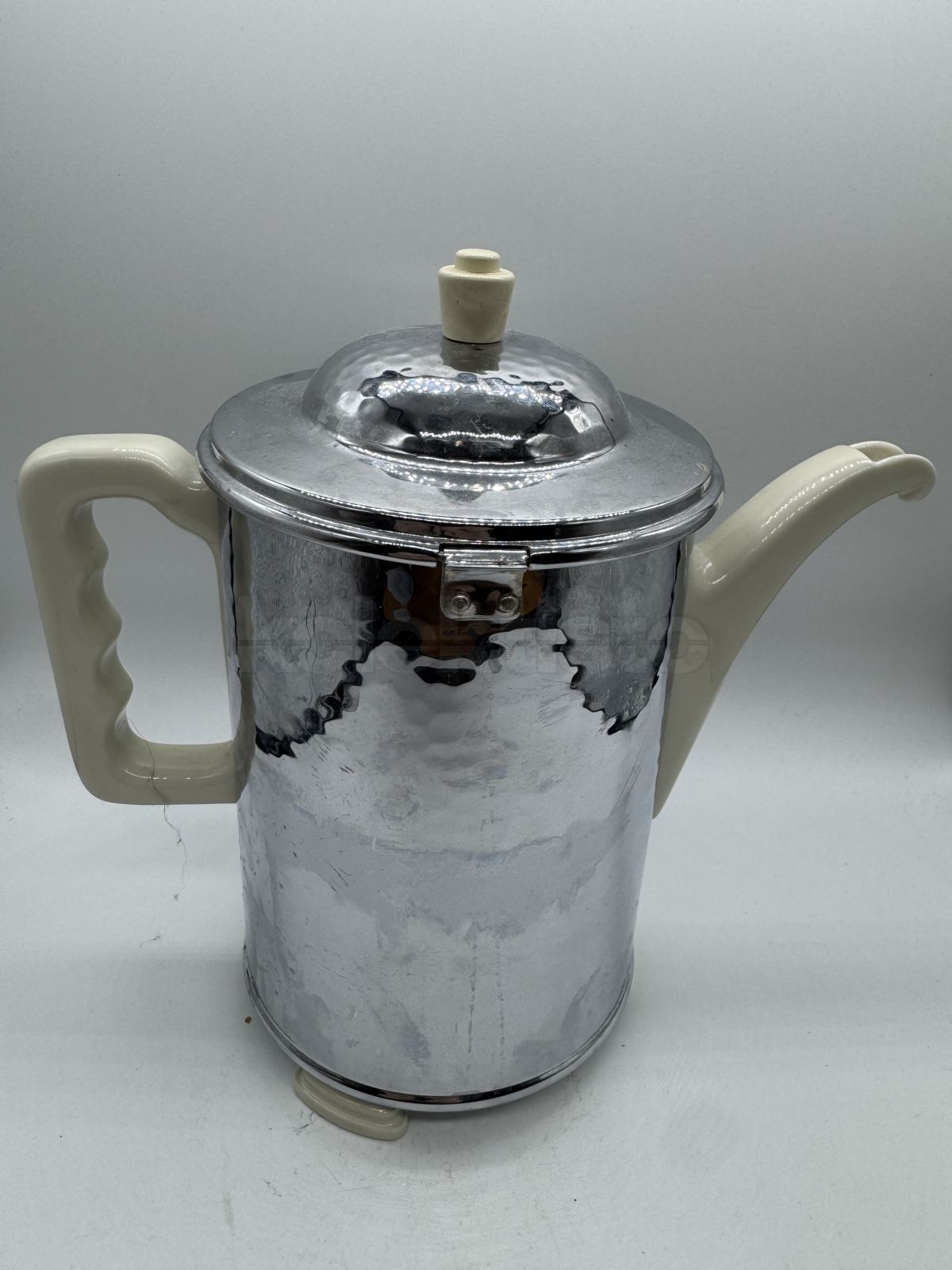 Porcelánová konvice s ochraným kovovým obalem a tepelnou izolací