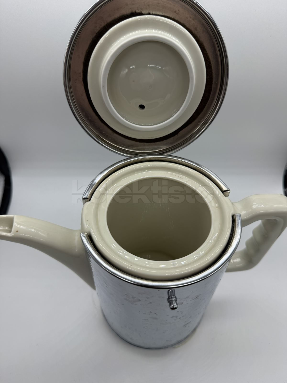 Porcelánová konvice s ochraným kovovým obalem a tepelnou izolací