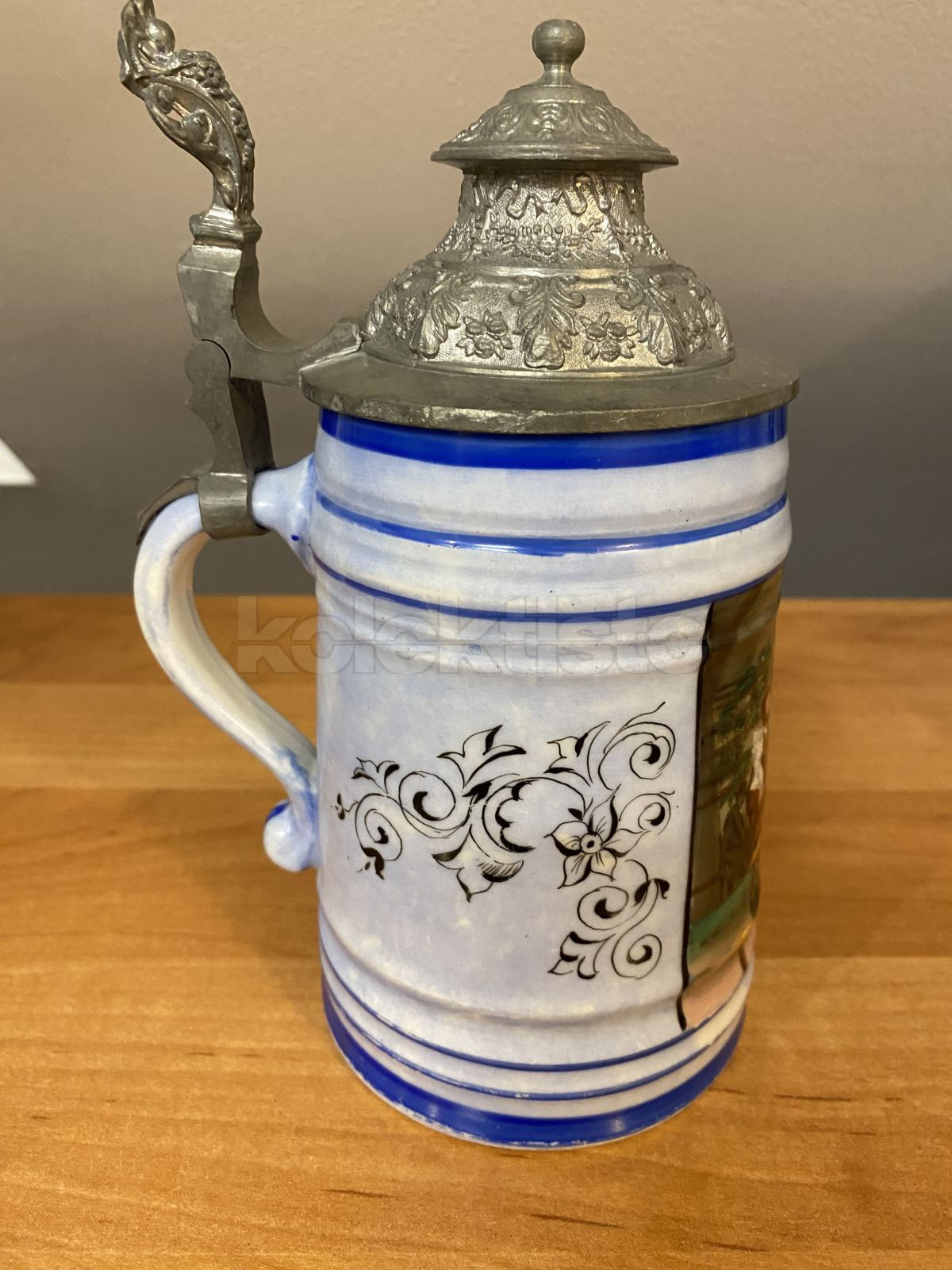Porcelánový korbel malovaný s cínovým víkem a průsvitkou na dně