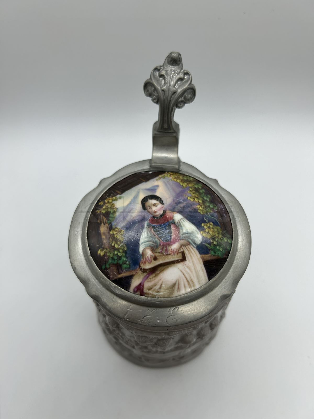 Keramický korbel s cínovým víkem a porcelánovým obrázkem se ženou hrající na citaru