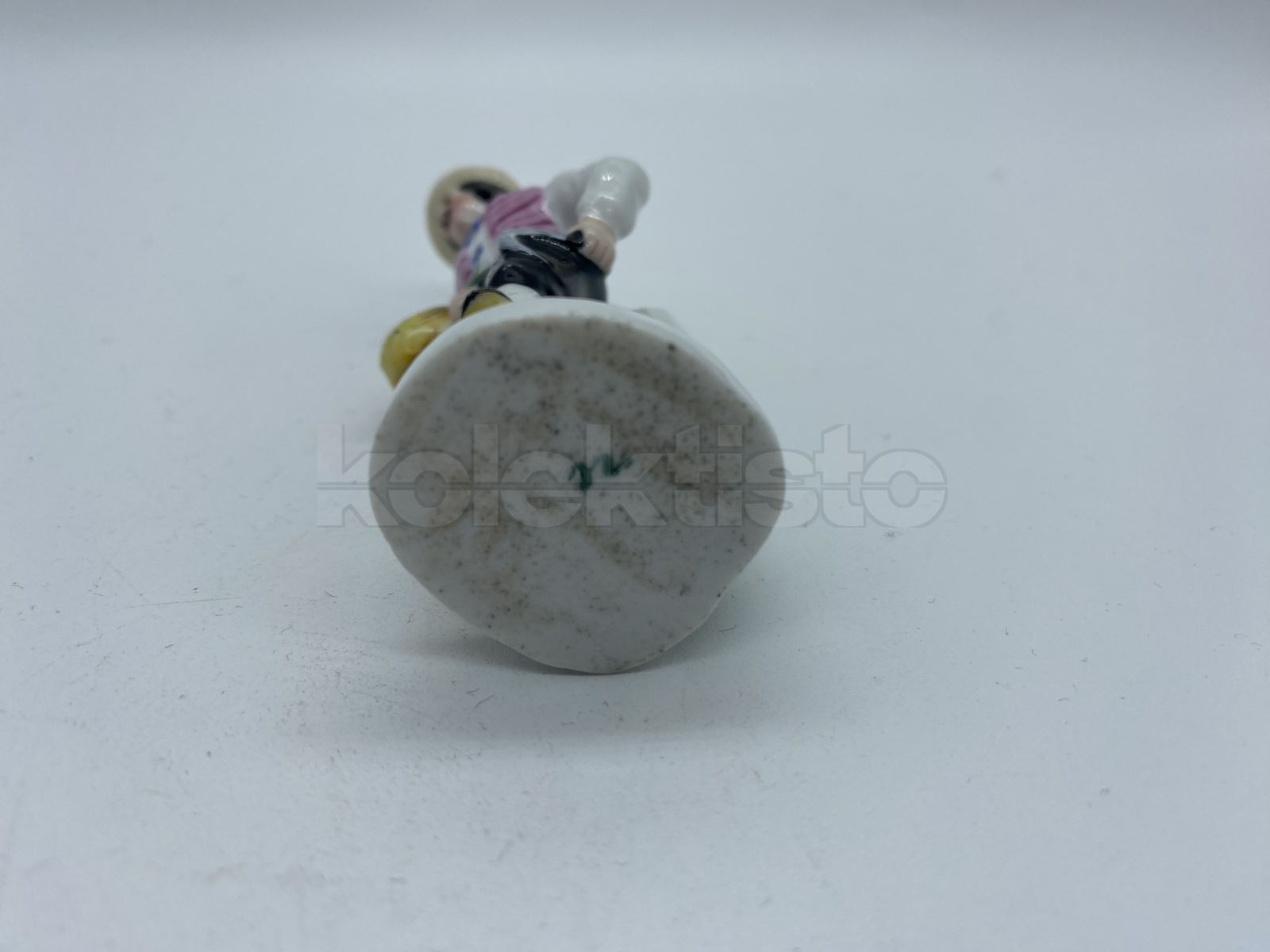 Porcelánová figurka muže se srpem