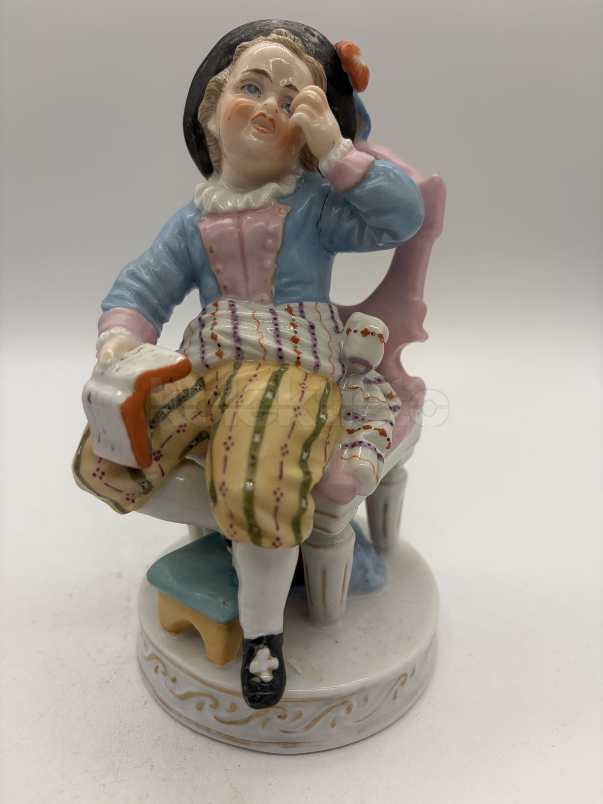 Porcelánová soška chlapce s knihou