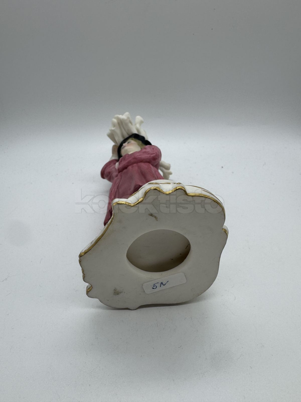 Porcelánová soška muže nesoucího klestí