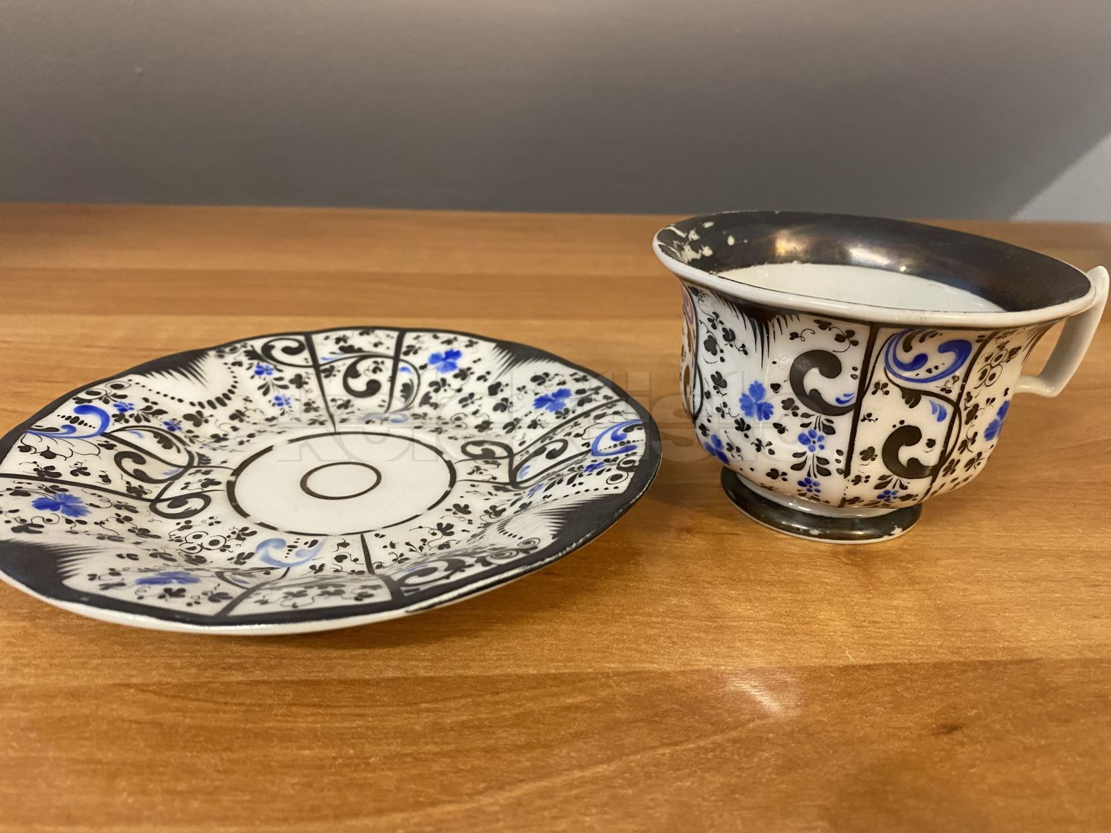 Porcelánový šálek s podšálkem zdobený modrou malbou a stříbrem