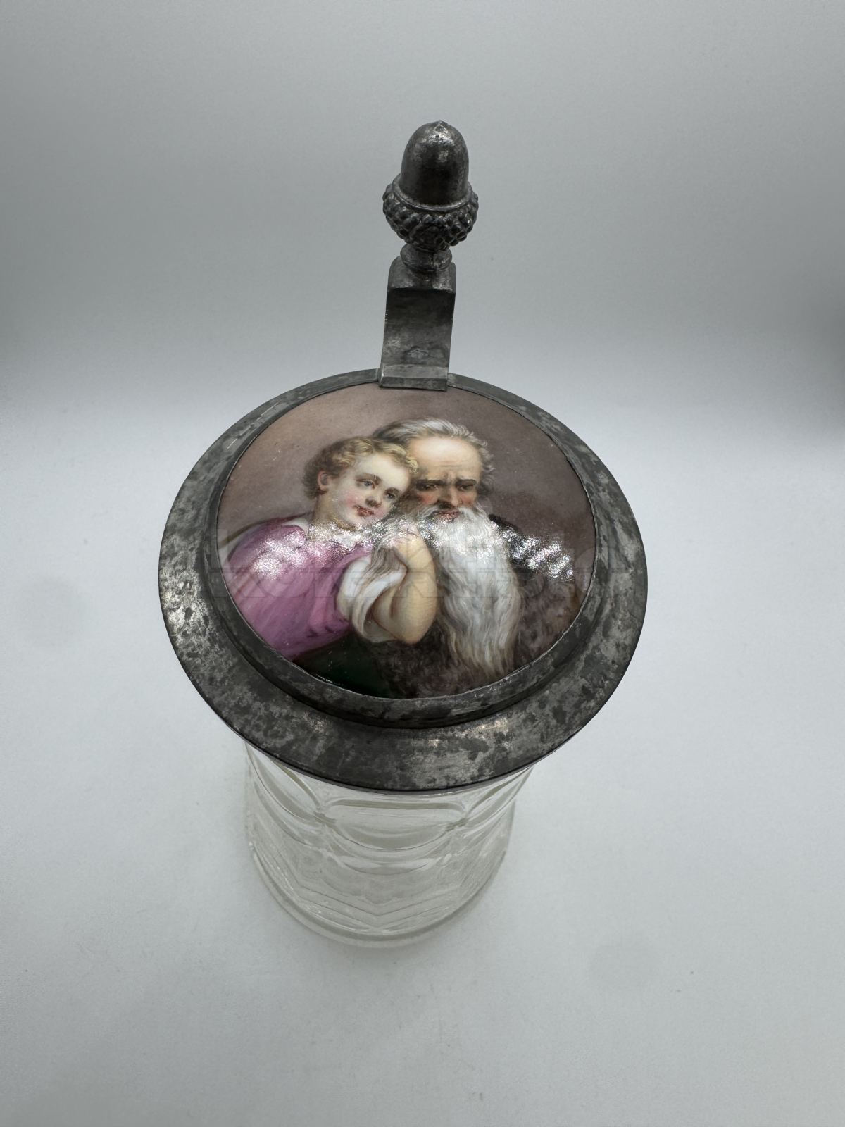 Korbel z čirého lisovaného skla s cínovým víčkem a malovaným porcelánovým obrázkem