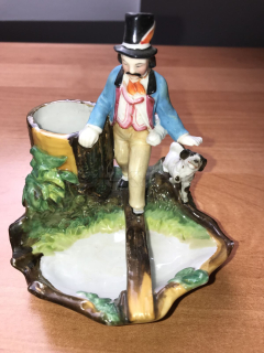 Porcelánová soška muže na lávce