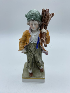 Porcelánová soška chlapce nesoucí klestí