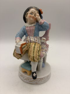 Porcelánová soška chlapce s knihou