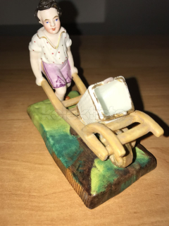 Porcelánová soška chlapce s trakařem