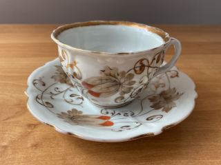 Porcelánový šálek s podšálkem, částečně smyté zlacení
