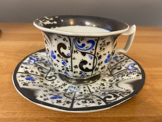 Porcelánový šálek s podšálkem zdobený modrou malbou a stříbrem
