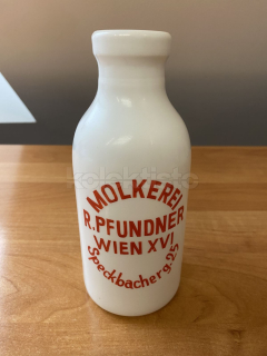 Skleněná láhev s reklamou na mléko