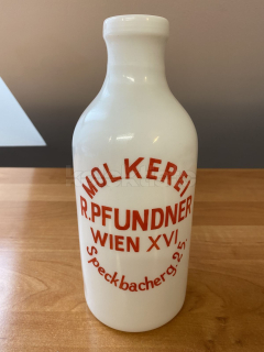 Skleněná láhev s reklamou na mléko